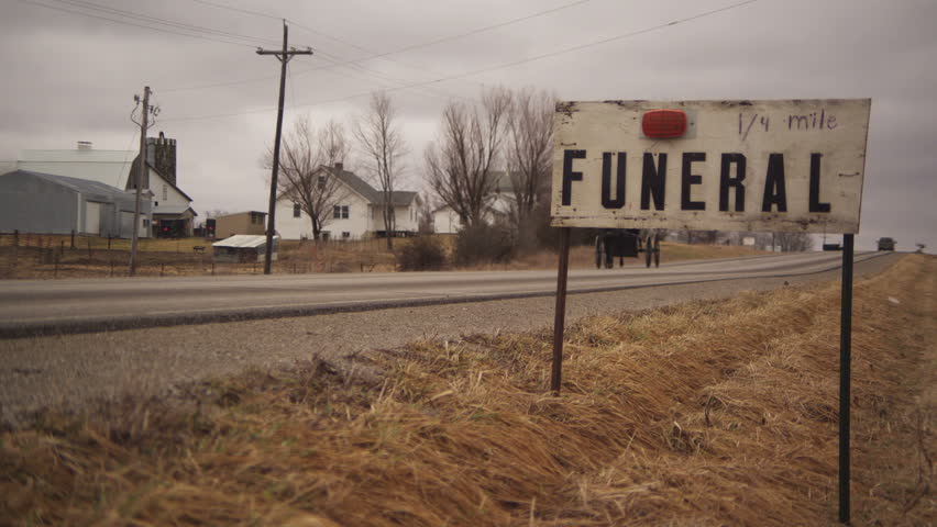 Amish funeral road sign with Amish buggy passing by