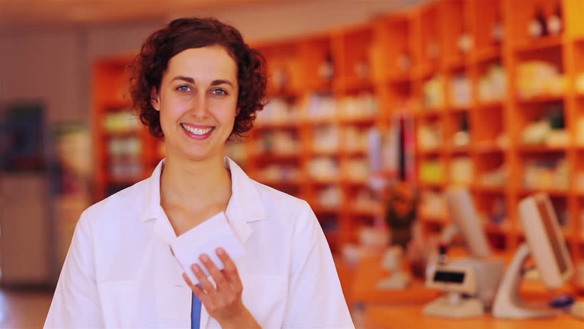 Happy pharmacist in pharmacy holding her thumb up