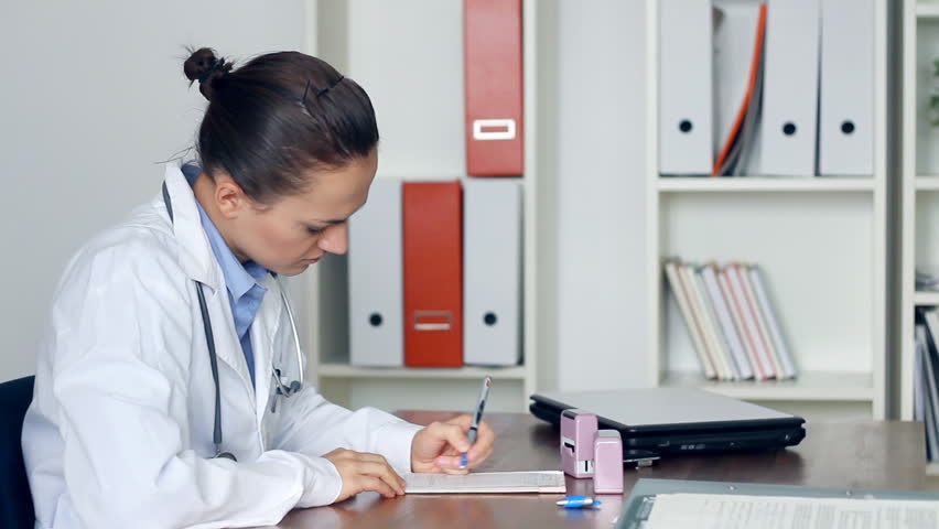 Female doctor writing rx prescription in the office