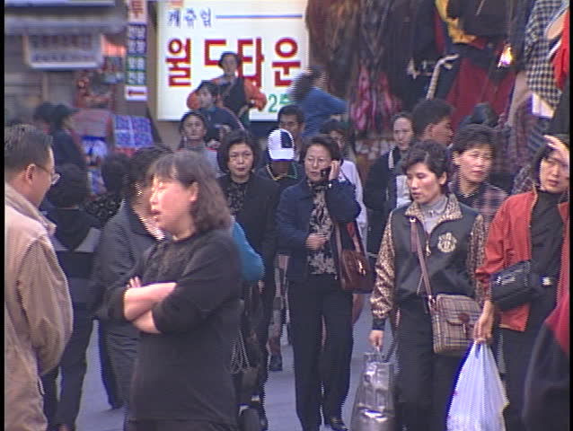 SEOUL, SOUTH KOREA - CIRCA 2006: Pedestrians walk and talk on a crowded city sidewalk circa 2006 in Seoul.