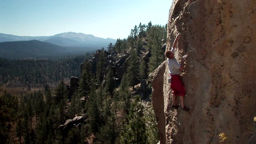 JOSHUA TREE, CA - CIRCA 2009: A man climbs up the side of a mountain circa 2009 in Joshua Tree.