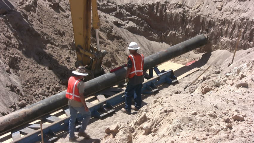 Men in a work zone laying a pipeline. 