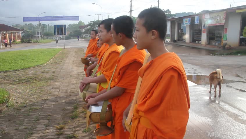 PHONSAVAN, LAOS - CIRCA SEPTEMBER 2011 - Women give food for the Buddhist monks on the street circa September 2011. 67% of the population of Laos is Theravada Buddhist.