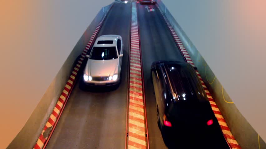 Car approach and passes by driveway in parking garage, view from above