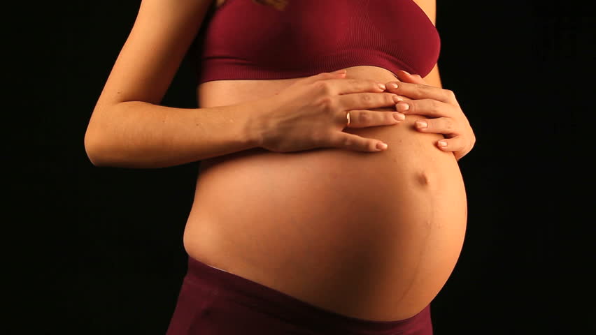 pretty young woman petting her pregnant belly