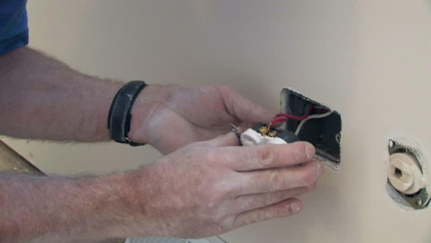Man installs an electrical outlet.