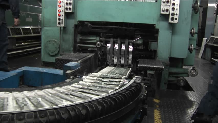 Newspapers move along an assembly line in a factory.