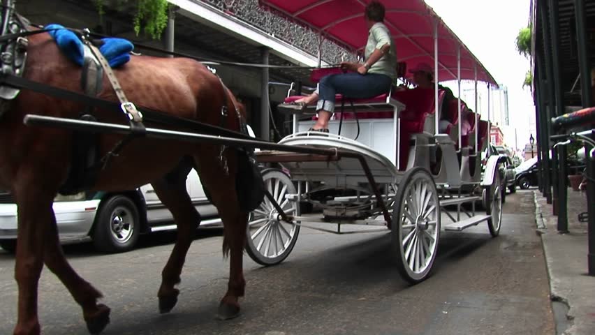 NEW ORLEANS - CIRCA 2009: A horse-drawn tourist carriage makes its way down a crowded street in New Orleans.