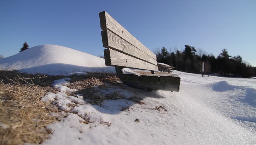 Wooden bench half-buried in snow