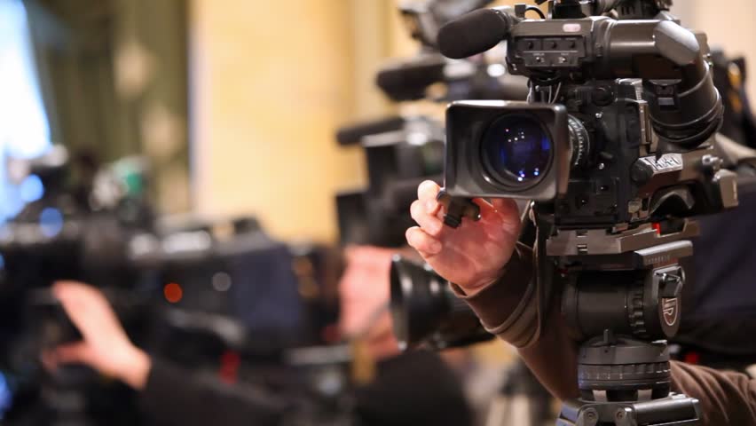 Videocamera and hands of operator, adjusting its close up