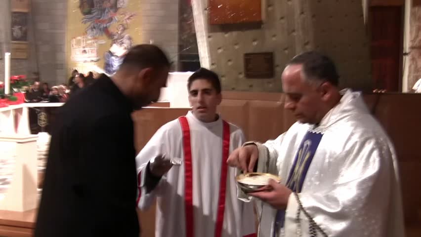 NAZARETH, ISRAEL - DEC 24, 2008: A priest administers communion at the Basilica of Annunciation on December 24, 2008 in Nazareth.