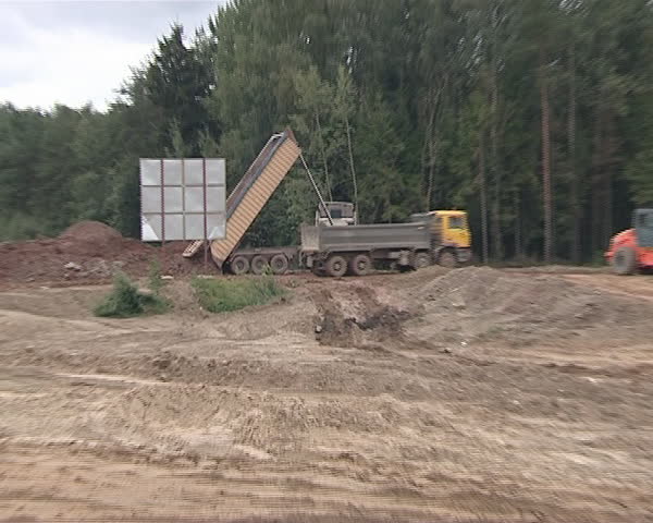 Construction industry. Heavy duty trucks. Truck dumps earth. 