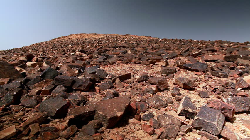 Low angled slide dolly move right to left of the rocky hillside of Ha-Minsara (The Carpentry Shop), a geological formation in the Mitzpe Ramon Crater in Israel.   