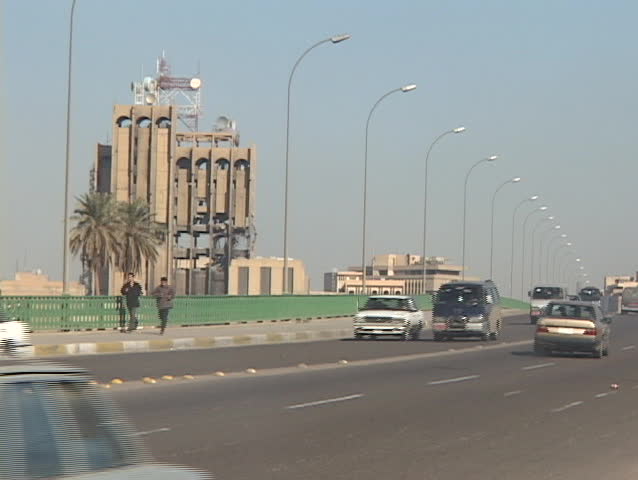  Iraqis  jog near a damaged building of war-torn Baghdad, Iraq.