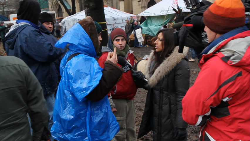 TORONTO, ONTARIO - NOV 23th: Reporter talks to protesters at Occupy Toronto on Nov 23rd, 2011, Toronto, Ontario, Canada. The site was closed down on Nov 23rd following a superior court judge ruling.