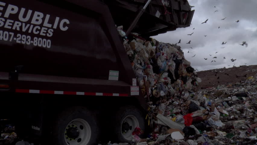 Dump truck unloads garbage at landfill