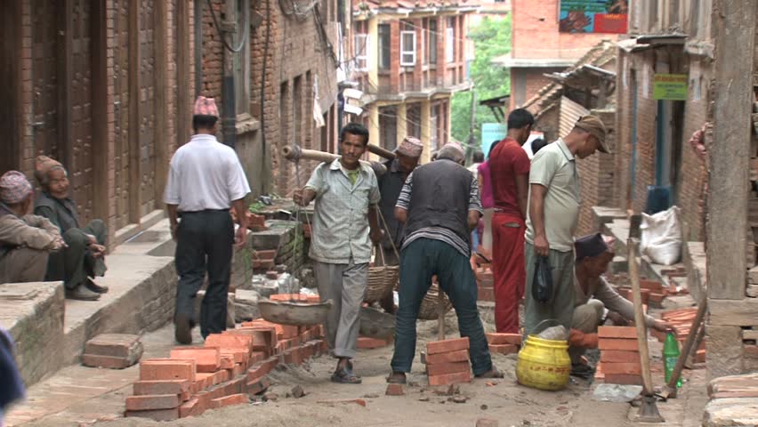 NEPAL - CIRCA MAY, 2011: Men balance baskets on their shoulders. 