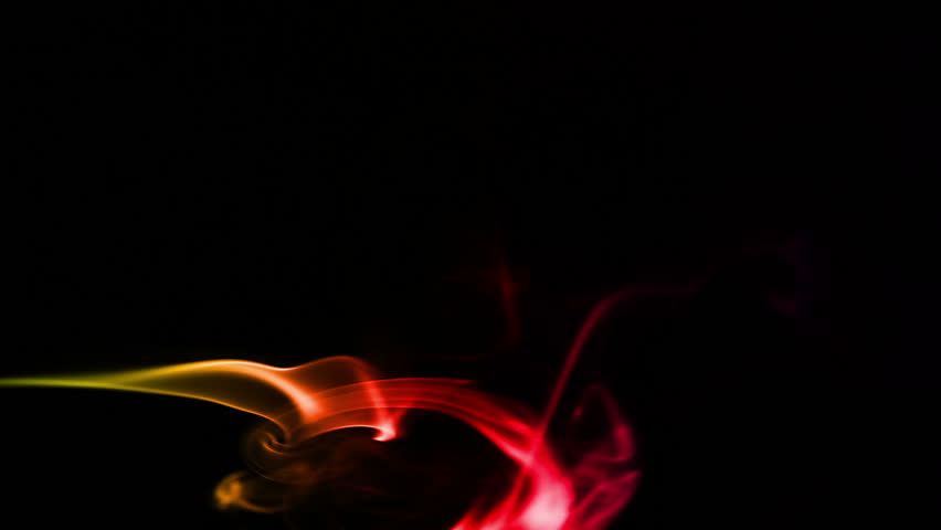 Multicolored smoke forming waves on Black background
