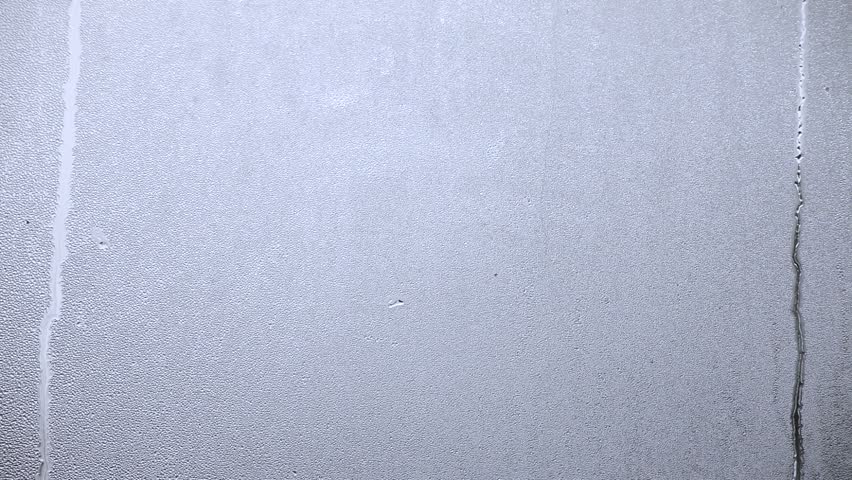 Hand writes VALENTINE on steamy window. 