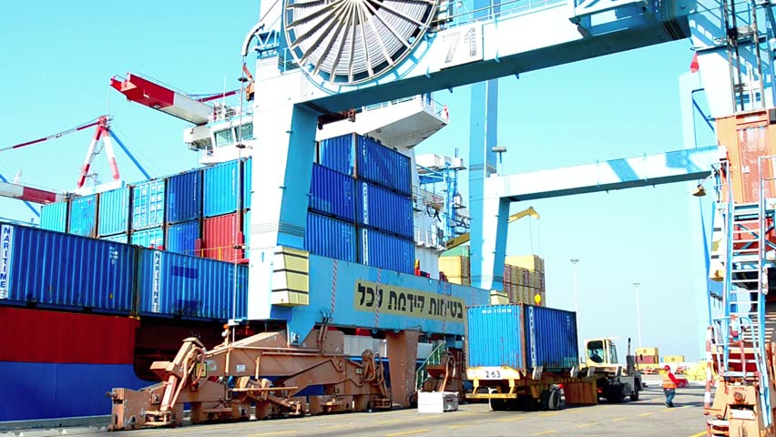 ASHDOD ISRAEL - DECEMBER 19: A cargo ship is loaded and unloaded by container crane in Ashdod seaport, Israel on December 19 2011.