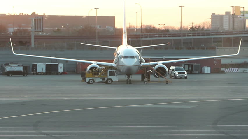 twin engine commercial jet plane being serviced on the tarmac.