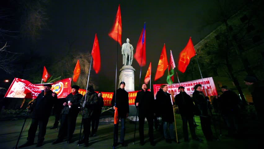 MOSCOW - MARCH 17: Several communists stand with flag in front of monument at approved meeting near metro station Chistiye Prudy on March 17, 2011 in Moscow, Russia.