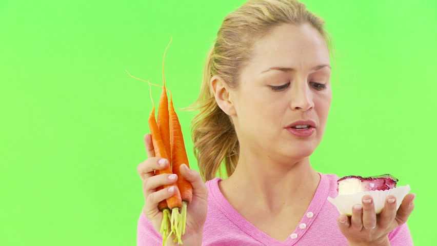 Close up of woman deciding between carrots and cake