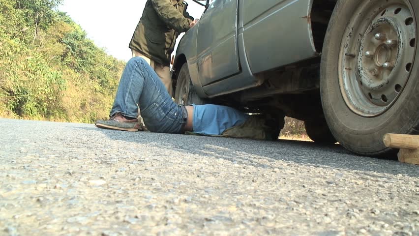 MUANG NGOI NEUA, LAOS - JANUARY 14, 2007: Fixing a broken down car