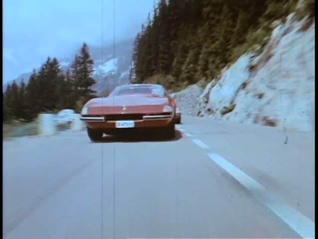 Two cars speeding through mountainside highway