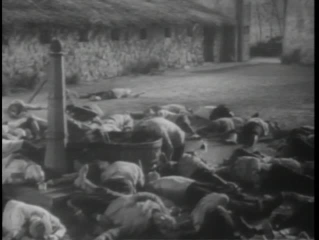 Historical reenactment World War II dead prisoners laying on ground by water pump