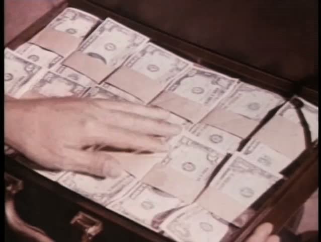 Close-up hand touching money in suitcase