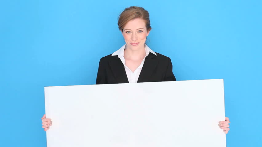 Happy smiling businesswoman holding a blank white sign tilted slightly , studio portrait on blue