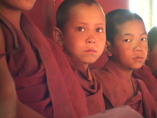 Buddhist boys sit in a row.