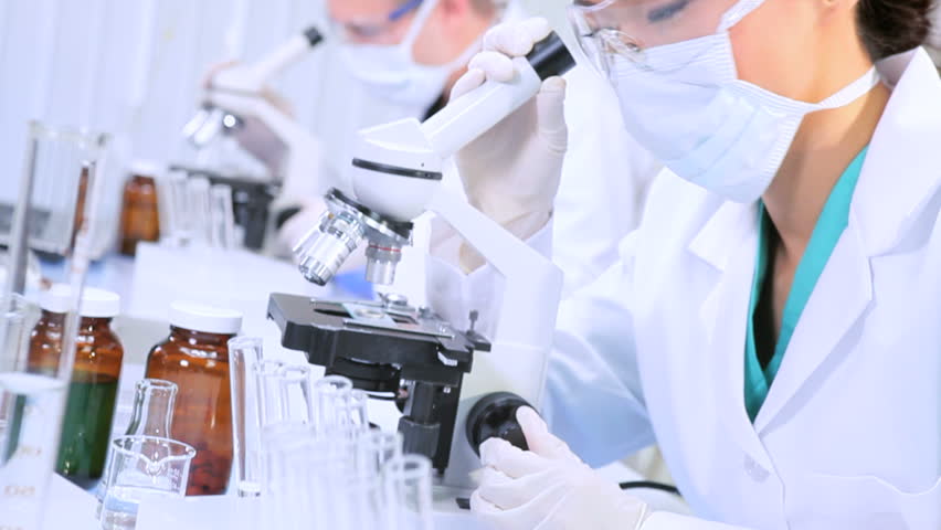 Medical researchers examining test tube specimens in sterile laboratory conditions