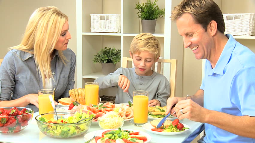Attractive young caucasian family eating a healthy meal together at the dining table