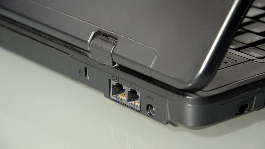Male hand plugging ethernet (network) cable in computer.