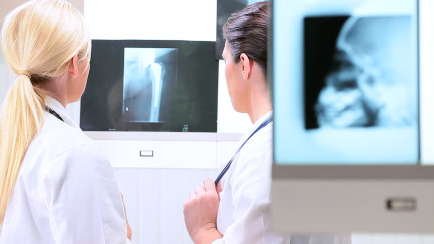 Young female doctors in hospital radiology department inspecting x-rays