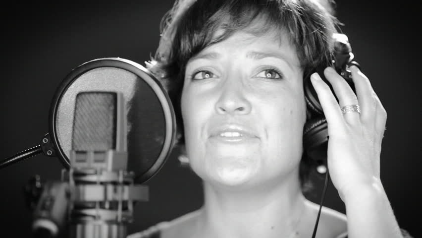 A young singer recording a song in a recording studio