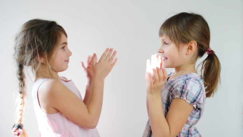 Two happy playful children laughing and playing pat-a-cake