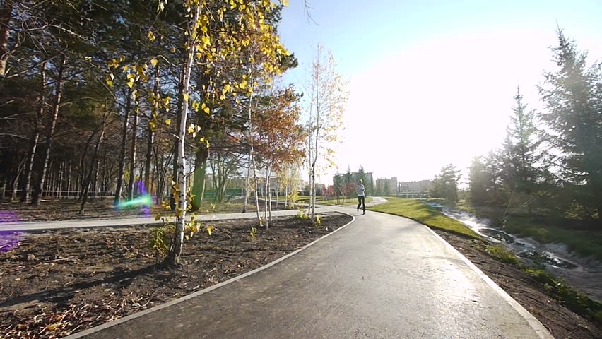 Girl runs through the park in the morning