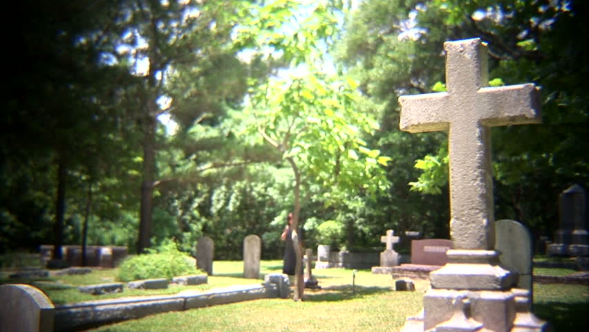 woman crying in a cemetery.  Note: Shot with a 35mm adapter to create a film shallow dof look.