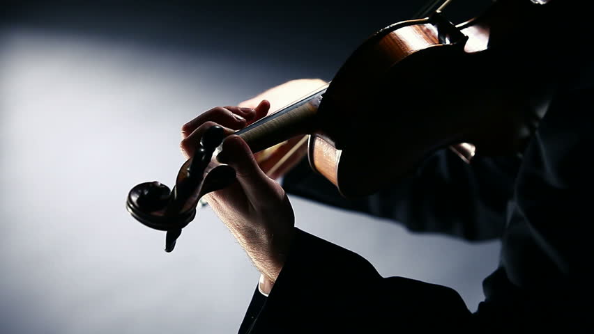 the violinist: Musician playing violin on dark background