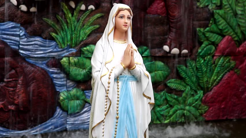 A praying virgin Mary statue with  fountain background
