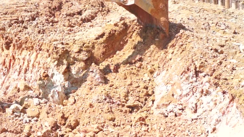 Close shot of Heavy excavator loader at soil moving works in construction site.