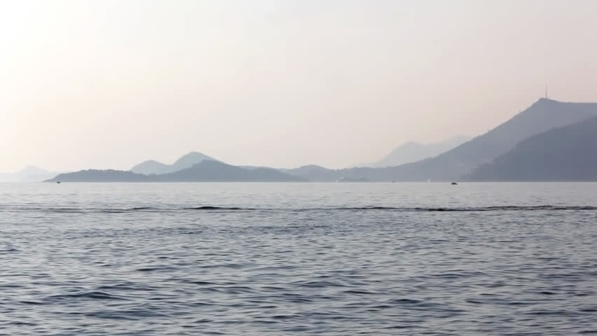 Adriatic sunset scene with a view to the Dubrovnik in the distance. Jet ski watercraft. Location small town Cavtat near Dubrovnik, Croatia