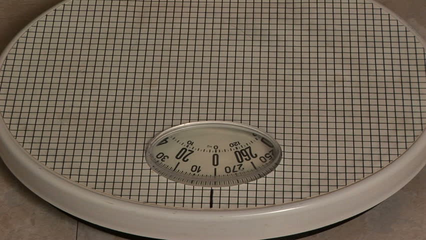 Woman stepping on a bathroom scale