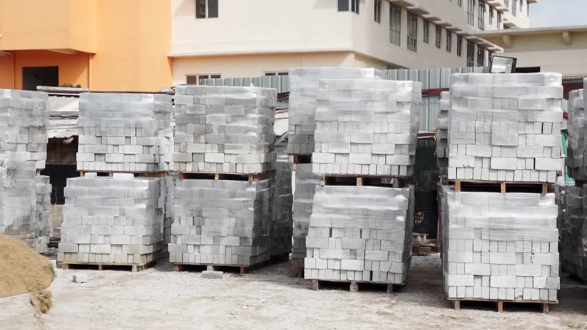 Worker handling heavy machinery to transport building material.