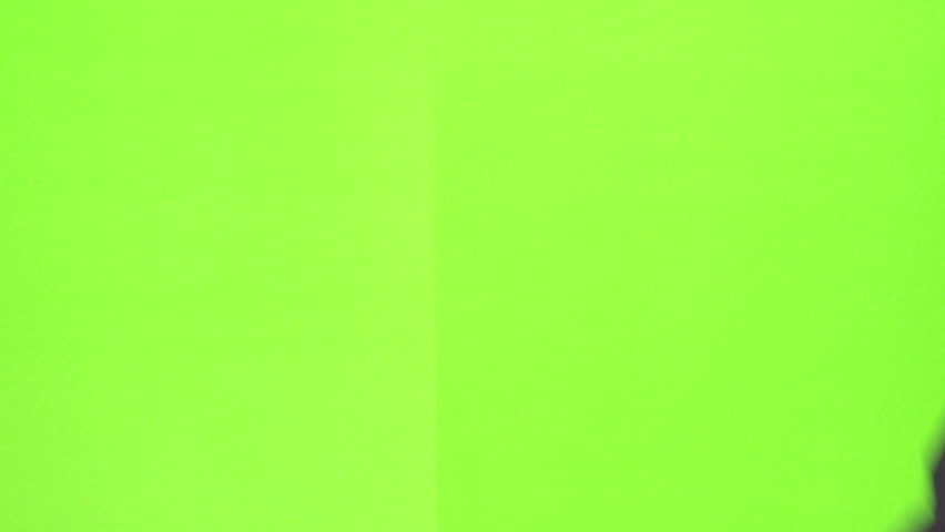 Man slating a take with clapper board on green screen, close up