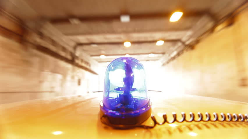 Car With Blue Emergency Light Driving Through A Tunnel