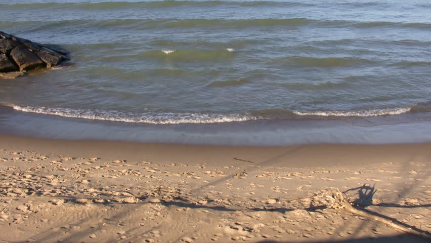 Waves gently hit the beach, then recede.  This is a medium shot with several oncoming waves visible. (High Definition)